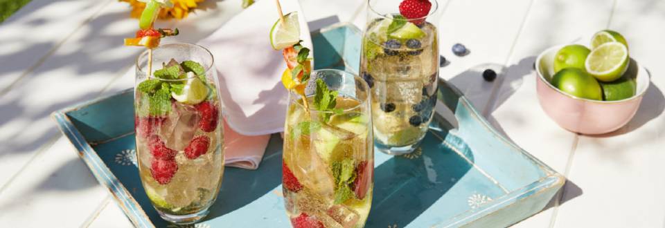 Sommerlicher Sekt-Cocktail mit Limetten, Beeren und Minze